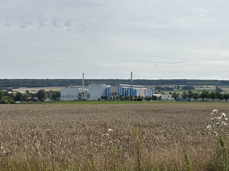 Eine Wiese und im Hintergrund ein Fabrikgelände