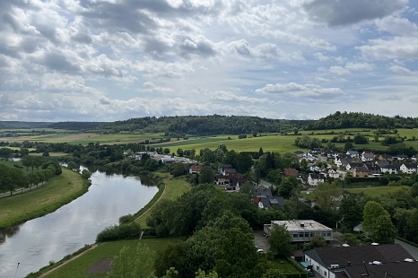 Eine Landschaft mit einem Fluss, einer kleinen Stadt und Bergen