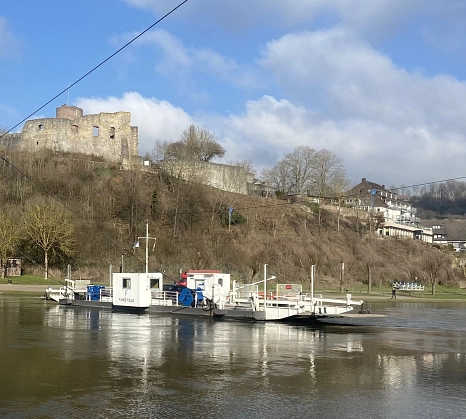 Eine Fähre die über ein Fluss fährt. Im Hintergrund sieht man ein kleines Waldstück an einem Berg. Auf dem Berg steht eine Burg.&nbsp;&copy;&nbsp;Landkreis Holzminden