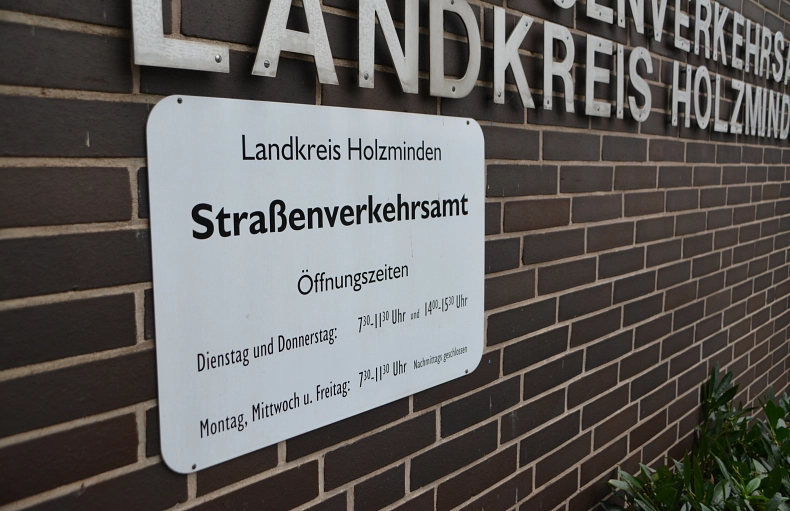 Straßenverkehrsamt 1 Symbol Braunes, verklinkertes Gebäude mit weißem Schild vom Straßenverkehrsamt
